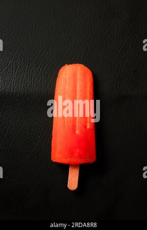 ice cream on a stick on a black background, close-up Stock Photo