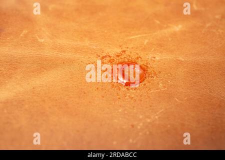 Ketchup stain on genuine brown leather texture, soft focus close up Stock Photo