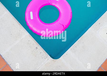 Bright pink float in blue swimming pool, close up view Stock Photo