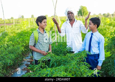 Indian three people standing in farm, farmer and his two son in farm happy family Stock Photo