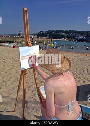 An artist paints the harbour & wharf, St Ives, Saint Ives , Cornwall, England, UK, TR26 1LP Stock Photo