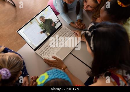 High angle view of diverse teacher and students studying online over laptop in school classroom Stock Photo