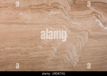 Unique texture of natural travertine, soft pattern of beige and brown wavy layers. Stock Photo