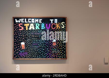 A welcome to Starbucks sign a a Danbury Mall shop which promotes products and left wing character traits. In Connecticut. Stock Photo