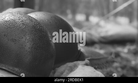 WWII American Metal Helmets Of United States Army Infantry Soldier At World War II. Helmets Near Camping Tent In Forest Camp Stock Photo