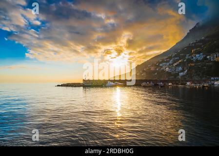 Crepuscular sun rays streaming through the clouds over Amalfi shoreline Stock Photo