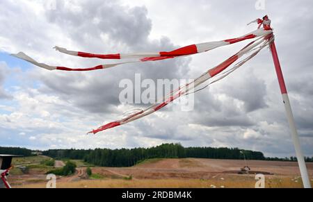 20 July 2023, Thuringia, Zwirtzschen: Barrier tapes wave during the cleanup of uranium ore mining legacies at the largest Wismut construction site in Thuringia. The Culmitzsch tailings facility collected residues from uranium ore processing. A total of four of these facilities occupied an area of about 570 hectares in western Saxony and eastern Thuringia. The cleanup of the Culmitzsch plant, which covers about 250 hectares, is expected to last until 2028 and is the most time-consuming Wismut cleanup. By 2022, the total remediation of contaminated sites from uranium mining would cost about 7 bi Stock Photo