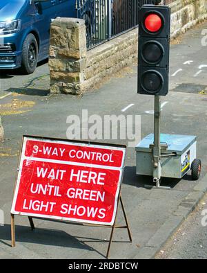 temporary traffic lights wait here until green light shows Stock Photo