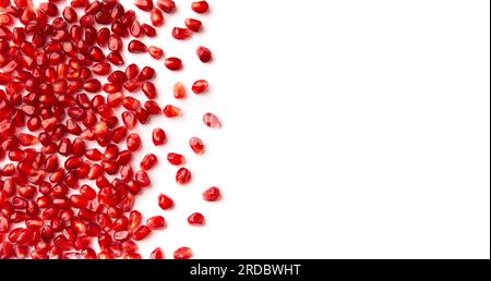 Red grains of a ripe pomegranate on a white background top view with place for text. Pomegranate grains on isolated flat lay. Background of pomegranat Stock Photo