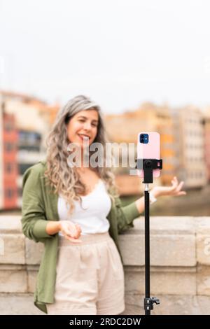 Influencer woman records herself talking about the city where she is located Stock Photo