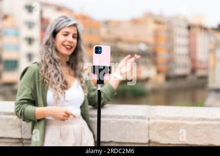 Influencer woman records herself talking about the city where she is located Stock Photo