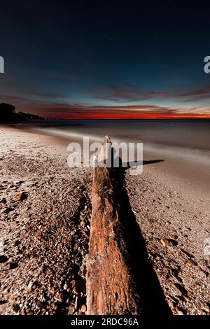 A lonely log on an Ohio beach. Lake Erie Stock Photo