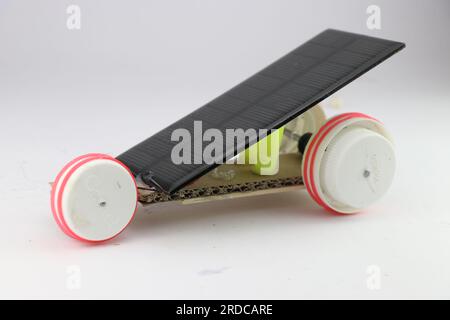 Solar powered car working model with inclined solar panels and wheels made from recycled plastic bottle caps isolated on white background Stock Photo