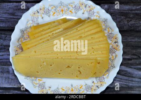 Slices of Egyptian Rumi cheese, also called gebna romiya or gebna turkiya, Roumi, Romi also Romy, middle Eastern parmesan hard cheese, has a pungent s Stock Photo