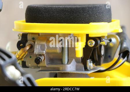 Side view of the carburetor in a petrol brush cutter machine with close up of foam filter, fuel supply hose and other parts Stock Photo