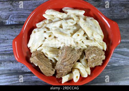 tasty appetizing classic pasta penne macaroni plate with white sauce, garlic, onion, spices, oil and black pepper with chunks of beef meat pieces cook Stock Photo