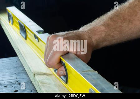 Construction level isolated on dark background held in hand industry backgrounds graphic design backgrounds Stock Photo