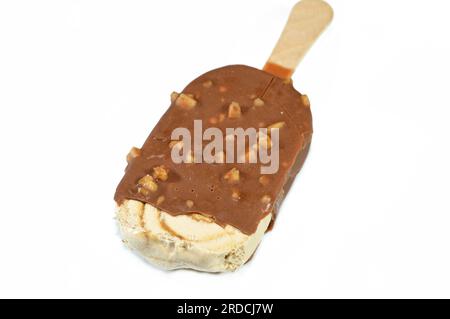 Salted caramel ice cream stick coated and covered with a layer of dark chocolate with nuts, Rich flavored ice cream in cracking brown chocolate crunch Stock Photo
