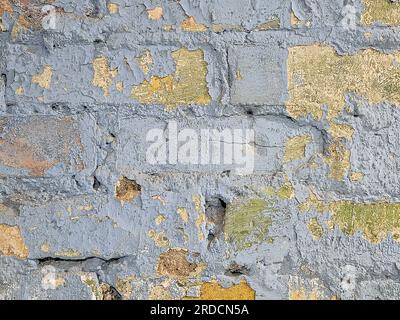 Old brick wall with peeling pastel blue paint Stock Photo
