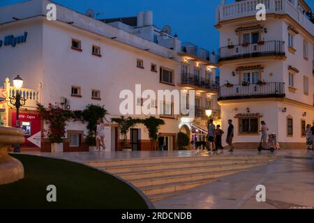 People walk through the cozy neighborhood of La Carihuela in the city of Torremolinos in the evening. Stock Photo