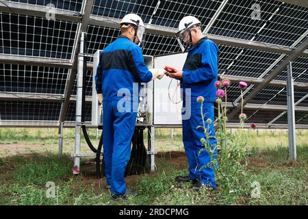 Two Service Engineers or electrician working on checking transformer site and solving problem for green energy solar power plant operation. Technician Stock Photo