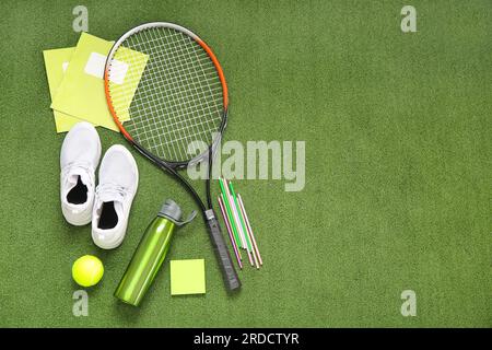 Sneakers with bottle of water, tennis ball, racket and different stationery on color background Stock Photo