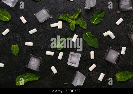 Fresh chewing gums with mint and ice cubes on black background Stock Photo