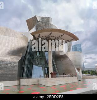 Bilbao Spain - 07 05 2021: Exterior view at the iconic Guggenheim Museum Bilbao, an iconic museum of modern and contemporary art, Nervion river and Bi Stock Photo