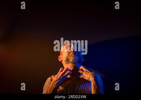 Funny bearded bald man doing different expressions and gestures. Happy, smiling a lot. Isolated on dark red background. Stock Photo
