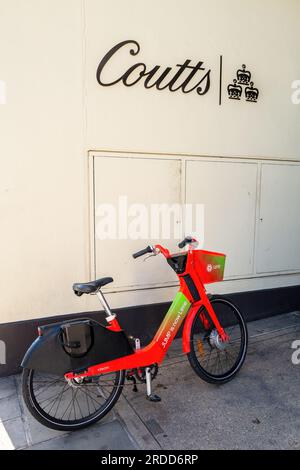 London, UK - 16 April 2022: A lime rental bike outside of Coutts Bank on the Strand, London. Coutts is an exclusive private bank and wealth manager fo Stock Photo