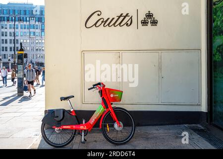 London, UK - 16 April 2022: A lime rental bike outside of Coutts Bank on the Strand, London. Coutts is an exclusive private bank and wealth manager fo Stock Photo