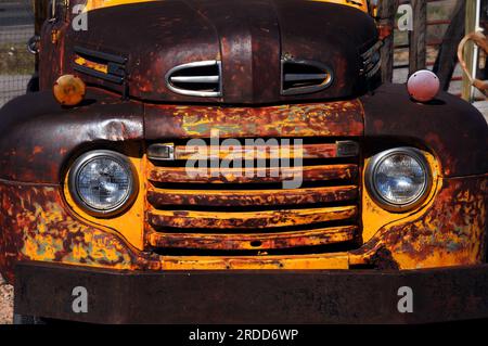 Vintage Ford truck rusts as it is exposed to the elements.  Yellow paint has almost peeled completely off. Stock Photo