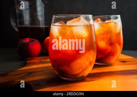 Glasses of Vietnamese Peach Iced Tea (Trà Dào): Iced tea served with slices of fresh peaches in the glasses Stock Photo