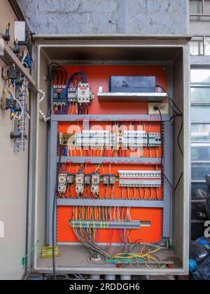Close-up view of the complex circuit box of a car shop  with the circuits identified by handwriting and with red tape in Spanish. Stock Photo