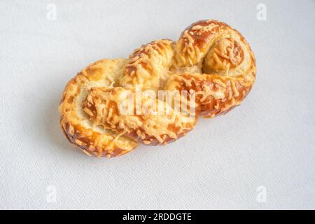 Soft pretzel bread topped with melted cheese, perfect for a savory and satisfying snack. Captured on a white background for a delicious presentation. Stock Photo