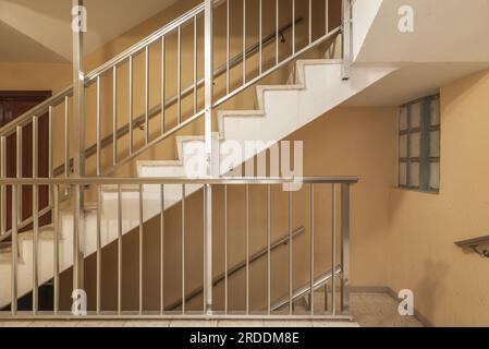 Flights of stairs with aluminum railings and handrails in a building without an elevator Stock Photo