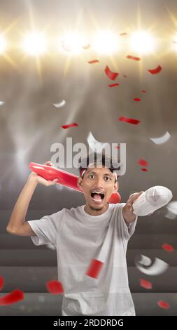 Indonesian man supporting the team when competing. Indonesian independence day Stock Photo