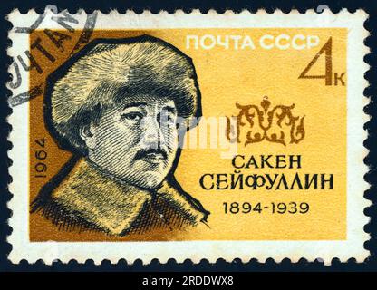 Saken Seifullin (1894 – 1938). Postage stamp issued in the USSR in 1964. Seifullin was a pioneer of modern Kazakh literature, poet and writer, and national activist. He was the founder and first head of the Union of Writers of Kazakhstan, he was the author of controversial literature calling for greater independence of Kazakhs from Soviet and Russian power. He met repression and was executed in 1938. The Soviet government posthumously rehabilitated him during de-Stalinization. Stock Photo