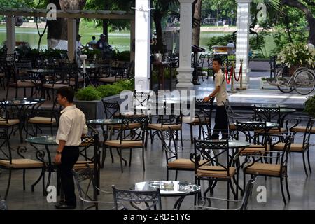 Young male waiters stand alert, waiting to welcome customers,  in an open air restaurant in central Hanoi ,Vietnam ,Asia, 2014 Stock Photo