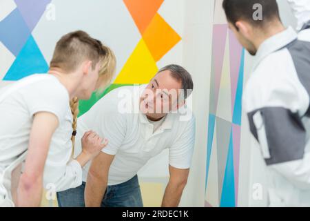 tutor inspecting students work on decorating course Stock Photo