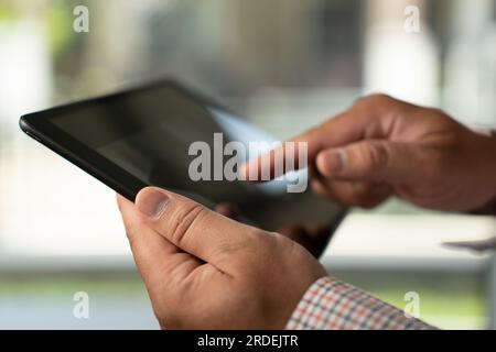 Man hands using looking and touch tablet laptop and cellphone communication mockup computer technology for tablet digital screen blank cyberspace onli Stock Photo