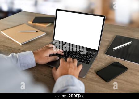 men using laptop computer working at office workspace with blank display white desktop screen monitor frame empty mockup for copy template advertising Stock Photo