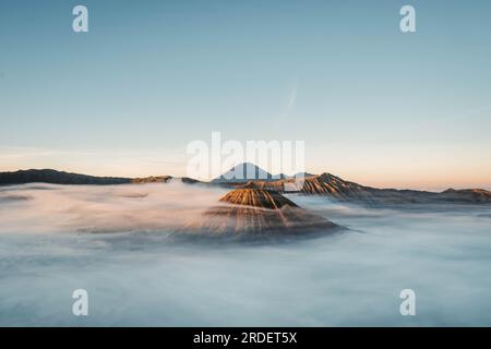 Gunung Bromo or Bromo Mountain is covered by clouds in the morning with clear blue sky Stock Photo