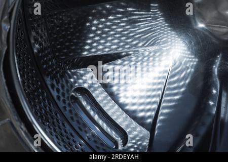 Shiny washing machine drum made of stainless steel, abstract industrial background texture Stock Photo
