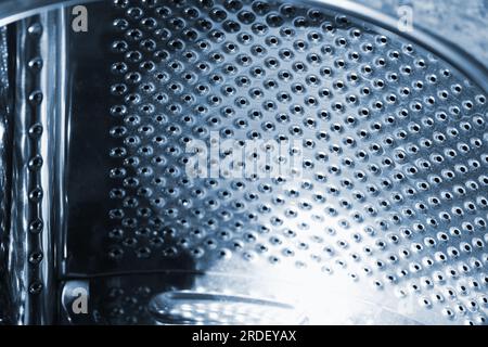Used washing machine drum made of stainless steel, abstract industrial background texture Stock Photo