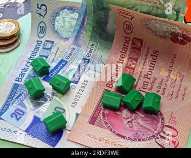 Accommodation costs ( buy or rent) in Northern Ireland, Sterling notes, coins, Monopoly houses Stock Photo