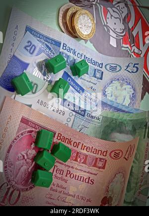 Accommodation costs ( buy or rent) in Northern Ireland, Sterling notes, coins, Monopoly houses Stock Photo