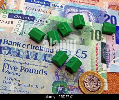 Accommodation costs ( buy or rent) in Northern Ireland, Sterling notes, coins, Monopoly houses Stock Photo