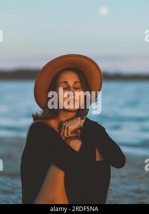 Young Woman By The Ocean Under The Full Moon Stock Photo