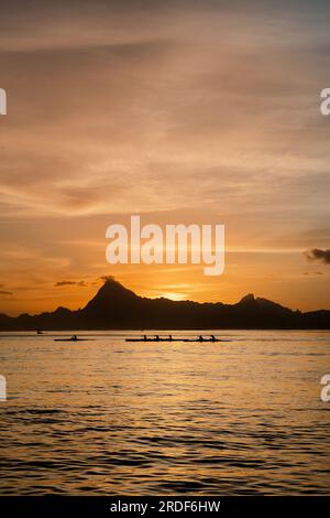 Sunset view Moorea island French Polynesia group of canoes Stock Photo